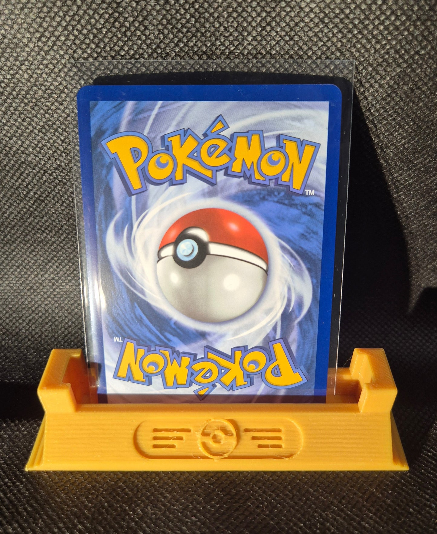 Pokémon Trading card in a protective holder on a textured surface