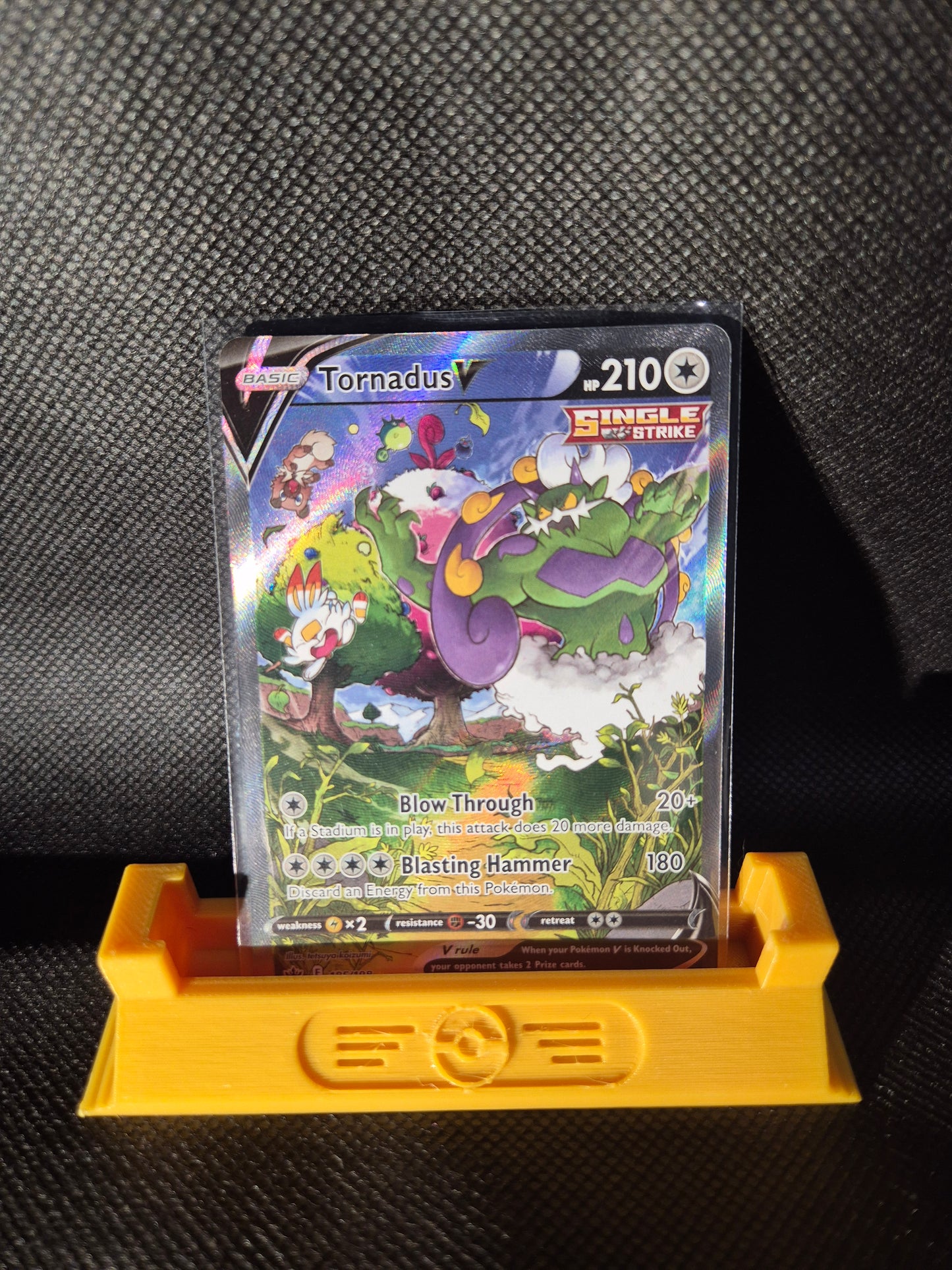 Trading card with colorful artwork on a black textured surface