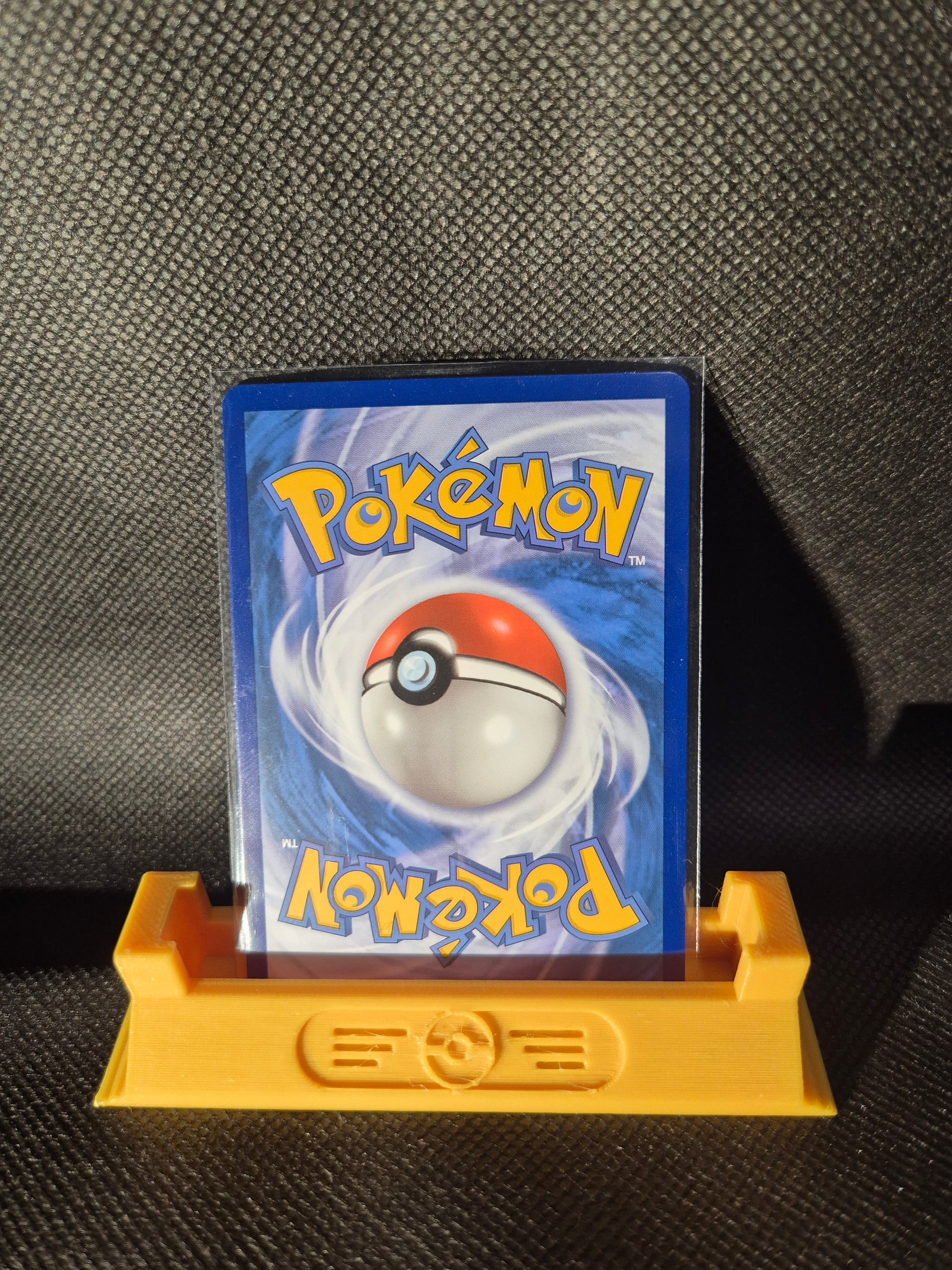 Trading card with colorful artwork on a black textured surface